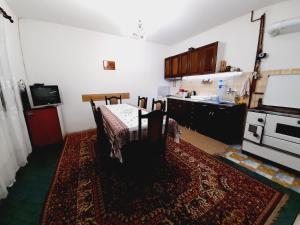 a kitchen with a table and a kitchen with a stove at Stefanovića kuća in Babušnica