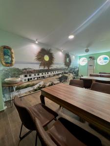 a restaurant with a table and chairs and a train mural at Hotel Florida in Durrës