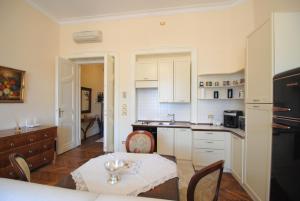 - une cuisine avec des placards blancs et une table dans une pièce dans l'établissement Premium Timisoara, à Timişoara