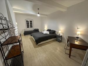 ein Schlafzimmer mit einem Bett und einem Schreibtisch. in der Unterkunft La Villa Bacchus in Groslée