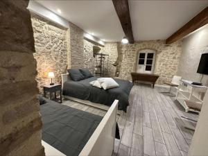 um quarto com uma cama e uma parede de pedra em La Villa Bacchus em Groslée