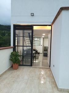 ein Haus mit Glastüren und einem Esszimmer in der Unterkunft El mirador paisa in Bello