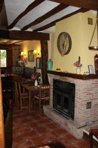 - un salon avec une cheminée, une table et des chaises dans l'établissement Casa Rural Uyarra, à Ojacastro