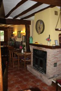 sala de estar con chimenea, mesa y sillas en Casa Rural Uyarra, en Ojacastro