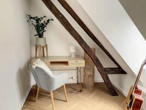 um quarto com uma cadeira e uma secretária com uma planta em L'Hippolyte - Cœur de ville em Compiègne
