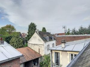 um grupo de edifícios numa cidade com telhados em L'Hippolyte - Cœur de ville em Compiègne