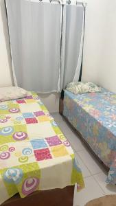 a bedroom with two beds and a quilt at casa prive paulista in Paulista