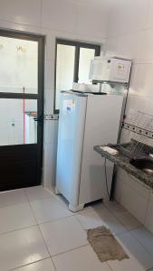 a kitchen with a white refrigerator and a microwave at casa prive paulista in Paulista