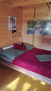 a large red bed in a wooden room at KORCAL faházak in Koroncó