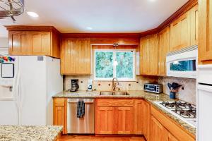 a kitchen with wooden cabinets and a white refrigerator at The Renton Rest House in Renton