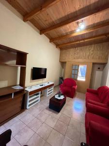 a living room with a red couch and a flat screen tv at La Casita de Irene in Puerto Rico