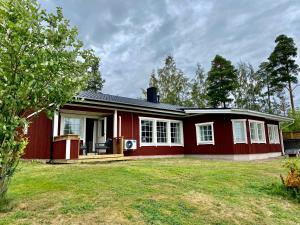 a red house with a lawn in front of it at Tirmo Strand in Porvoo