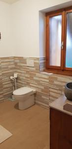 a bathroom with a toilet and a window at Antica Corte da Edi in San Daniele del Friuli