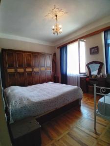 a bedroom with a bed and a chandelier at sulkhanihouse in Batumi