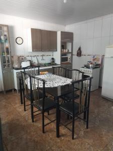 uma cozinha com uma mesa com cadeiras e um frigorífico em Casa refúgio em Santana do Livramento