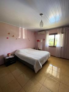 um quarto com uma cama grande e uma janela em Casa refúgio em Santana do Livramento