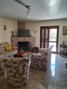 sala de estar con 2 sofás y chimenea en Casa refúgio, en Santana do Livramento