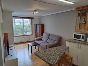 ein Wohnzimmer mit einem Sofa und einem Tisch in der Unterkunft Piso Millenium in Ourense