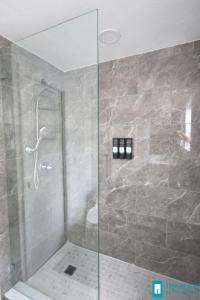 a bathroom with a shower with a glass door at 251 Airport/Top House Apartments in Miami