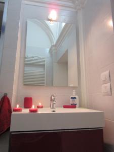 a bathroom with a sink with a mirror and candles at LE GEMME DI PERUGIA - alloggi in centro storico - VIA DELLA CUPA / VIA DELLA LUNA in Perugia +135 photos