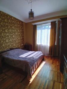 a bedroom with a large bed and a window at sulkhanihouse in Batumi