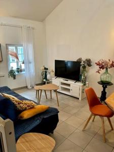 a living room with a couch and a flat screen tv at Duplex en plein centre-ville in Morestel