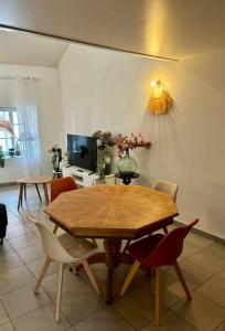 a dining room with a wooden table and chairs at Duplex en plein centre-ville in Morestel