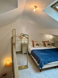 a bedroom with a bed with a blue blanket at Duplex en plein centre-ville in Morestel