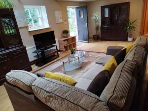 a living room with a couch and a tv at grange cottage 3 bedroom in Edenderry