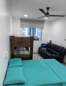 ein Wohnzimmer mit einem Sofa und einem Deckenventilator in der Unterkunft Hermosa casa Ricaurte in Girardot