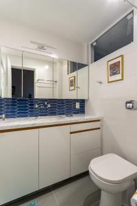 a white bathroom with a toilet and a sink at Maravilha no Leme - Até 4 pessoas - GRC701 Z5 in Rio de Janeiro