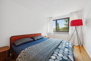 a bedroom with a bed and a red lamp at EXQUIS Kunstvolles Luxusapartment I Designmöbel I Balkon I Homeoffice I Parken I Netflix in Böblingen