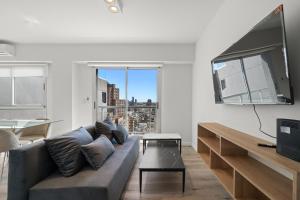 a living room with a couch and a large window at La Vie Suite Barrio Norte in Buenos Aires