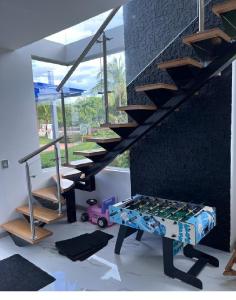 ein Wohnzimmer mit einer Treppe und einem Tisch mit einem Spielzeugwagen in der Unterkunft Hermosa casa Ricaurte in Girardot