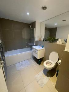 a bathroom with a toilet and a sink and a tub at 1 Bedroom Flat in London CB46 in Croydon
