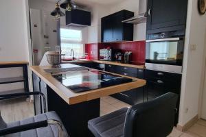 une cuisine avec des armoires noires et un comptoir dans l'établissement Appartement les Angles clim WiFi, aux Angles (Gard)