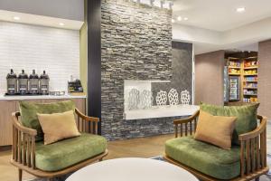 a lobby with two chairs and a stone wall at Fairfield Inn by Marriott Tracy in Tracy