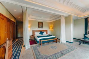 - une chambre dotée d'un lit avec des draps bleus et blancs dans l'établissement Palace Jena, à Marrakech