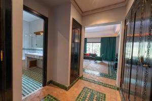 un couloir menant à une chambre avec salle de bains. dans l'établissement Palace Jena, à Marrakech