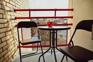 a table and two chairs in front of a window at M lux Kragujevac in Kragujevac