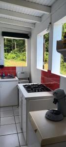 a kitchen with a stove and a sink and two windows at Weston in Deshaies +22 photos