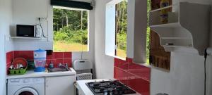 a small kitchen with a stove and a sink at Weston in Deshaies
