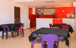 um quarto com duas mesas e cadeiras roxas e uma cozinha em Godmill City Guesthouse Taung em Lethola