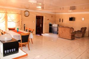 uma cozinha e sala de jantar com mesa e cadeiras em Godmill City Guesthouse Taung em Lethola