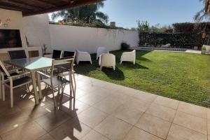 eine Terrasse mit einem Tisch, Stühlen und einer Liegewiese in der Unterkunft Casa Pascal, Bº Villa Belgrano in Cordoba