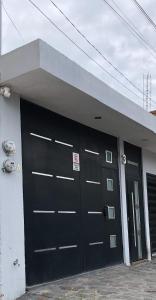 um edifício com duas grandes portas de garagem pretas em Loft en tequila Jalisco em Tequila