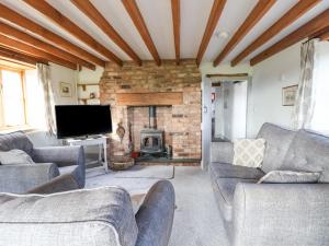 a living room with couches and a fireplace at Rhydonnen Bach in Denbigh