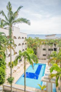 - une vue sur la piscine d'un complexe avec des palmiers dans l'établissement Paramar, à Ubatuba