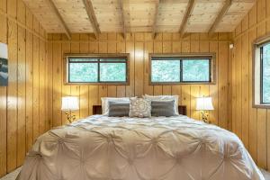 1 dormitorio con 1 cama grande y 2 ventanas en Edgewater Escape by Sarah Bernard, with Hot Tub, en Innsbrook