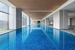 a swimming pool with blue tiles in a building at Sheraton Mianyang in Mianyang